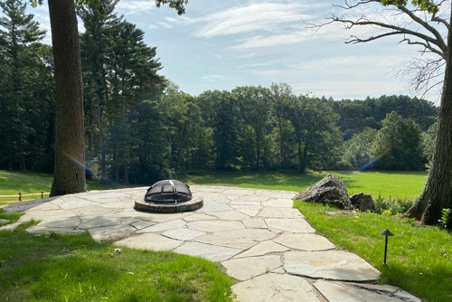 Fire pit with custom cover and natural flagging patio by New View